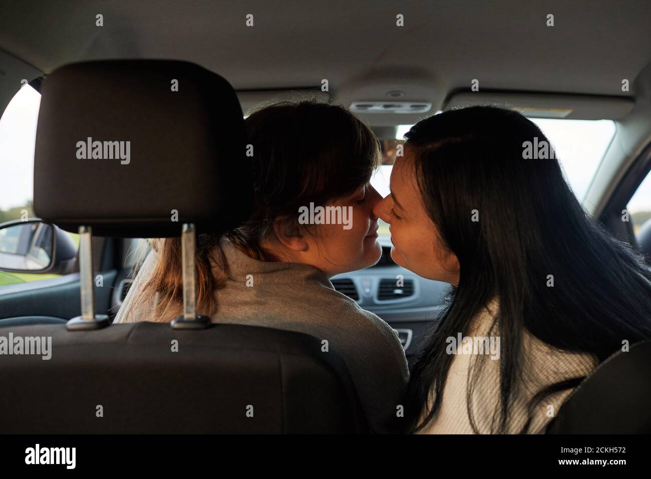 Rear View Of Two Lesbians Kissing While Sitting In The Car During Their