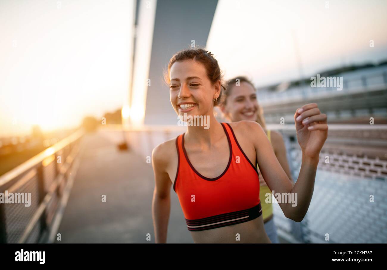 Beautiful happy women friends working out, exercising, running, jogging  outdoor Stock Photo - Alamy