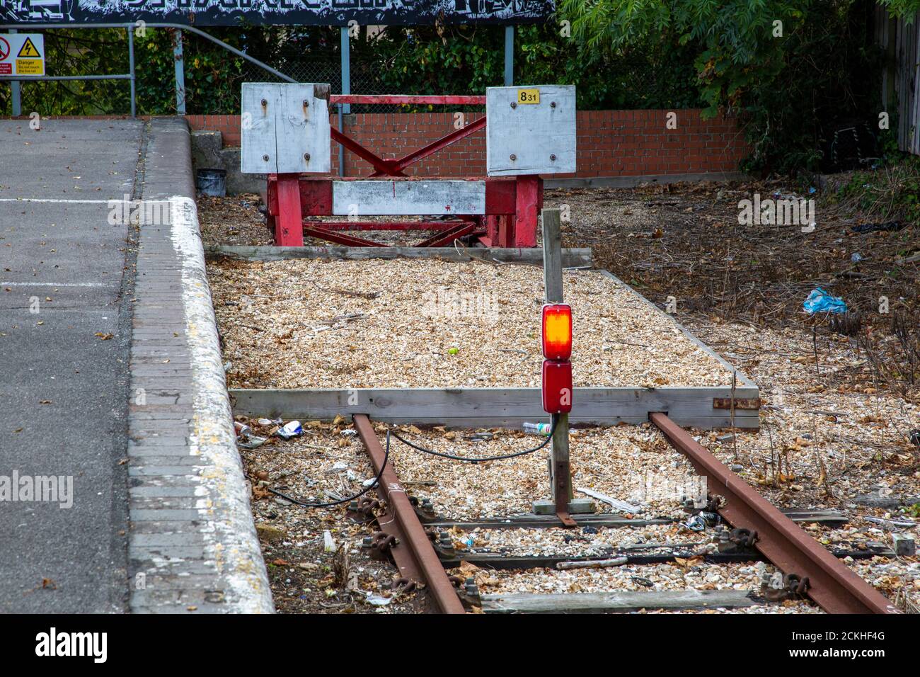 A buffer stop and warning lights at the end of a train track Stock Photo