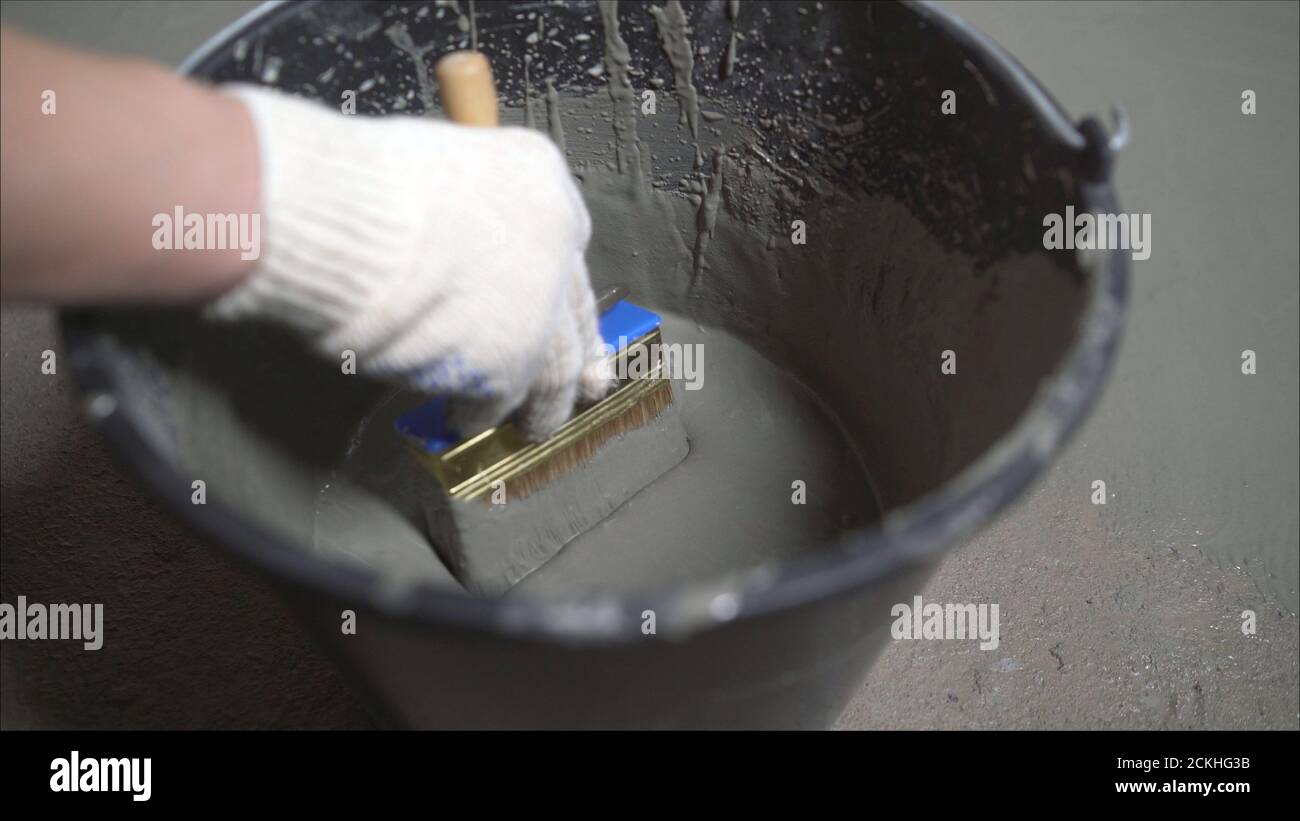 Waterproofing concrete floor with mortar and brush. An industrial