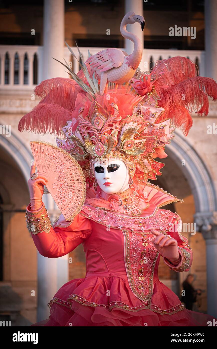 Traditional carneval costume/mask posing early morning at the waterfront during a sunrise at the annual carnival in Venice, Italy Stock Photo