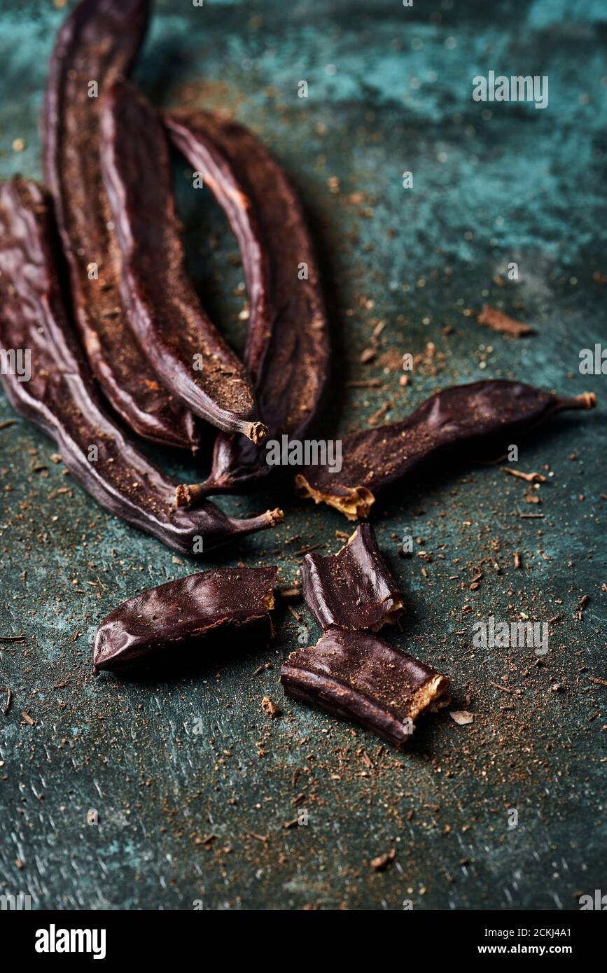 some ripe carob beans on a rustic dark green surface Stock Photo Alamy