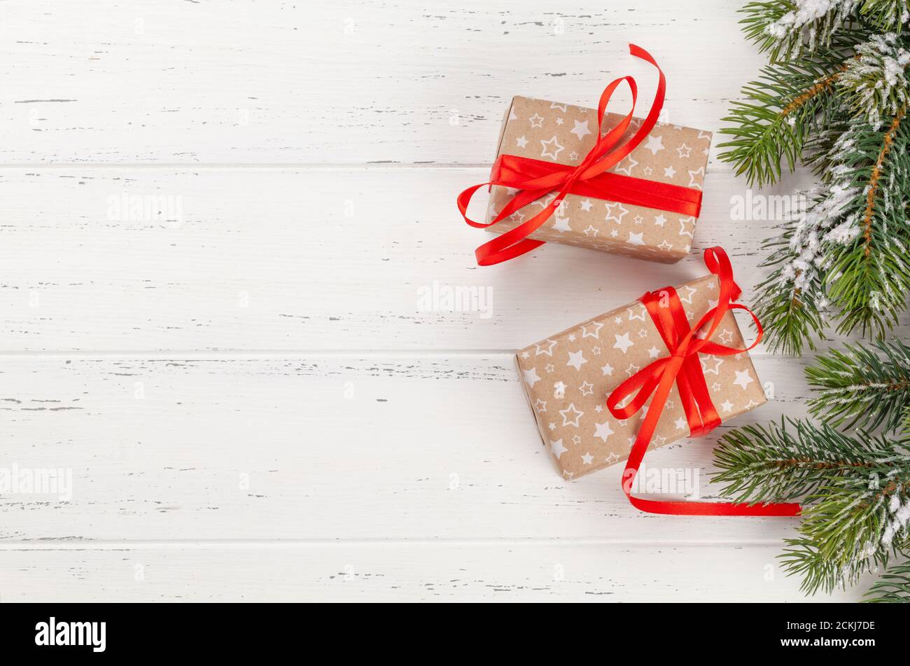 Christmas gift boxes and fir tree over wooden background with space for ...