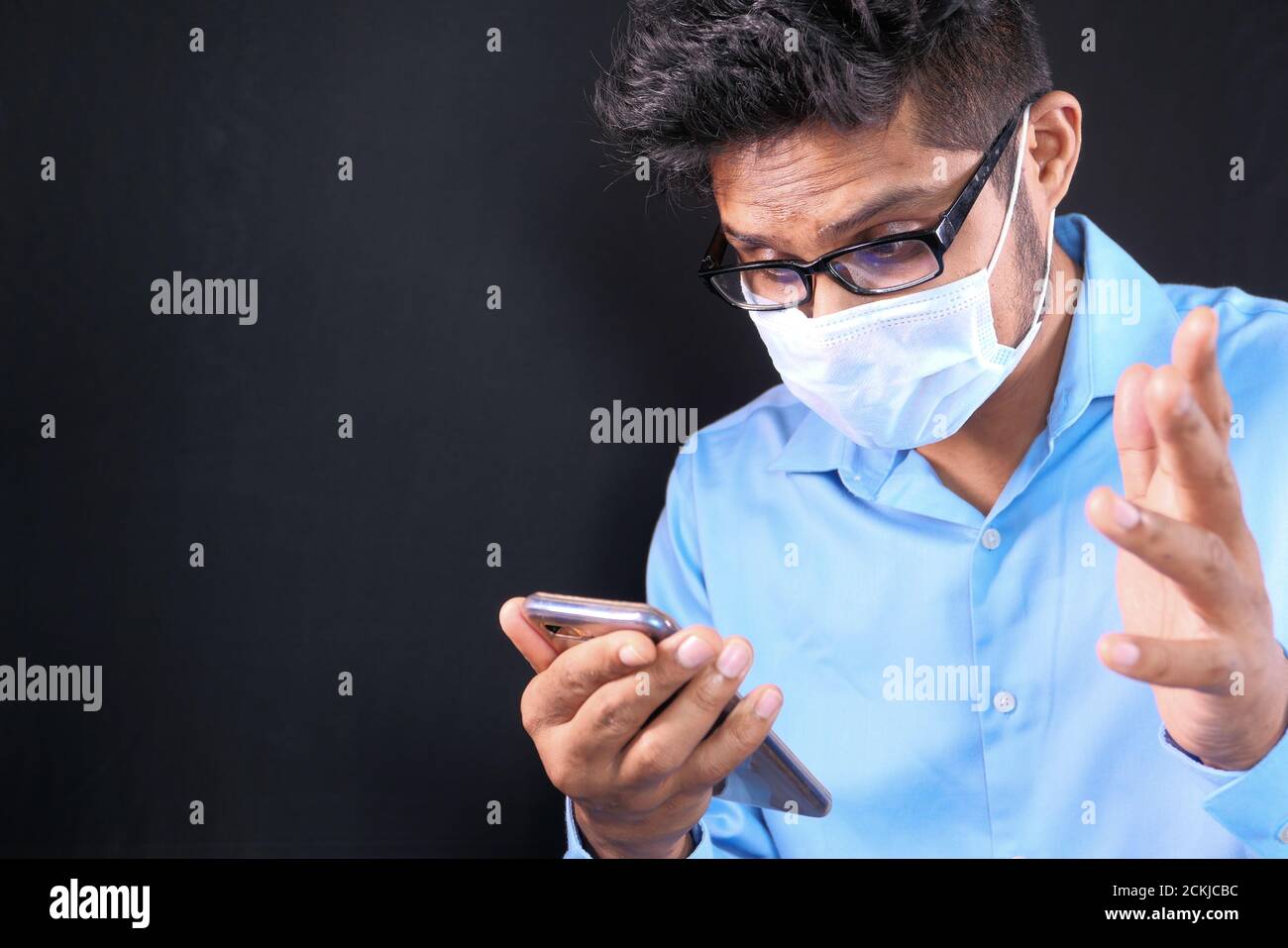 young man with face mask using smart phone indoor  Stock Photo