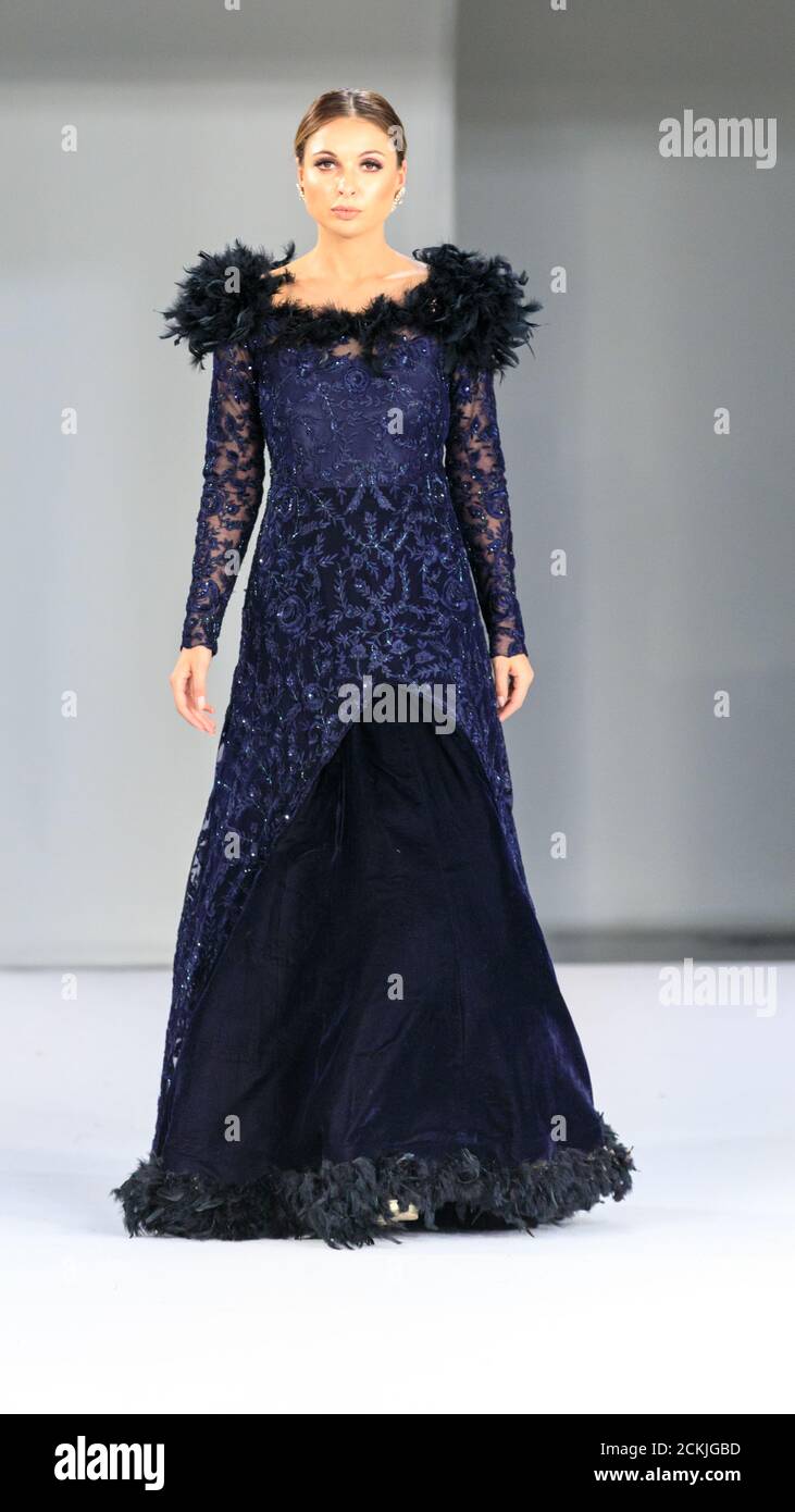 Model wearing couture and bridal wear gown by Amar Kular, in dark blue, National Asian Wedding Show fashion runway, London Stock Photo