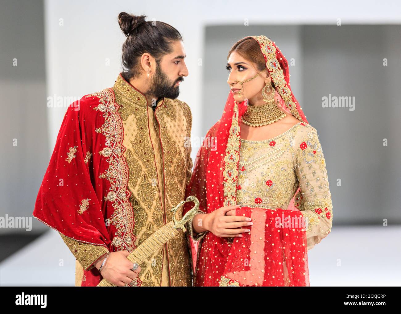 Model bride and groom, Asian wedding dress bridal wear, gown by Sache by Asif, National Asian Wedding Show fashion runway, London Stock Photo