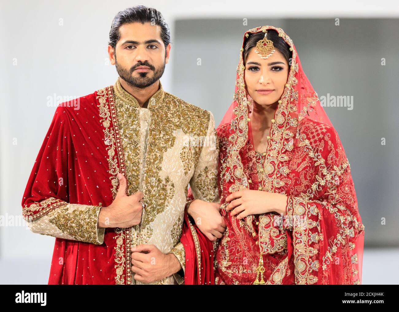 Model bride and groom, Asian wedding dress bridal wear, gown by Sache by Asif, National Asian Wedding Show fashion runway, London Stock Photo