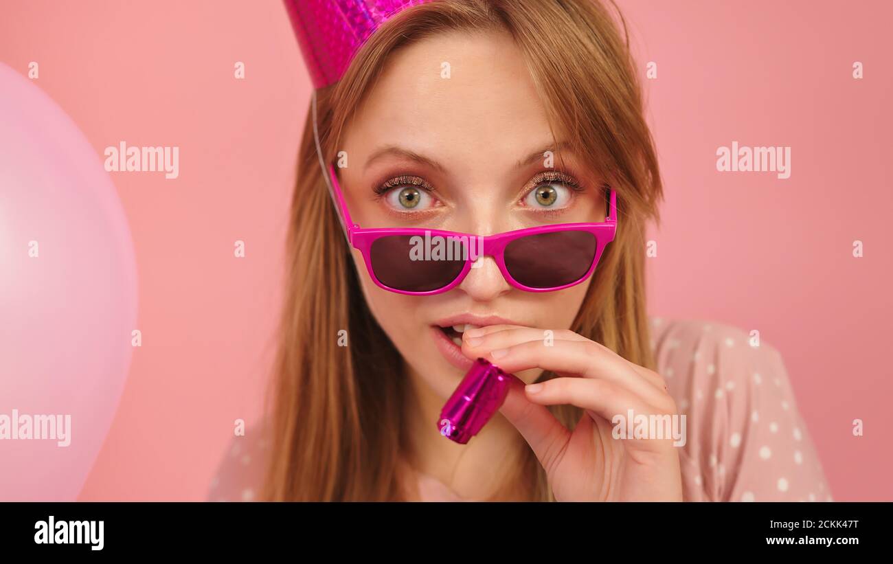 Young woman blowing party horn hi-res stock photography and images - Alamy