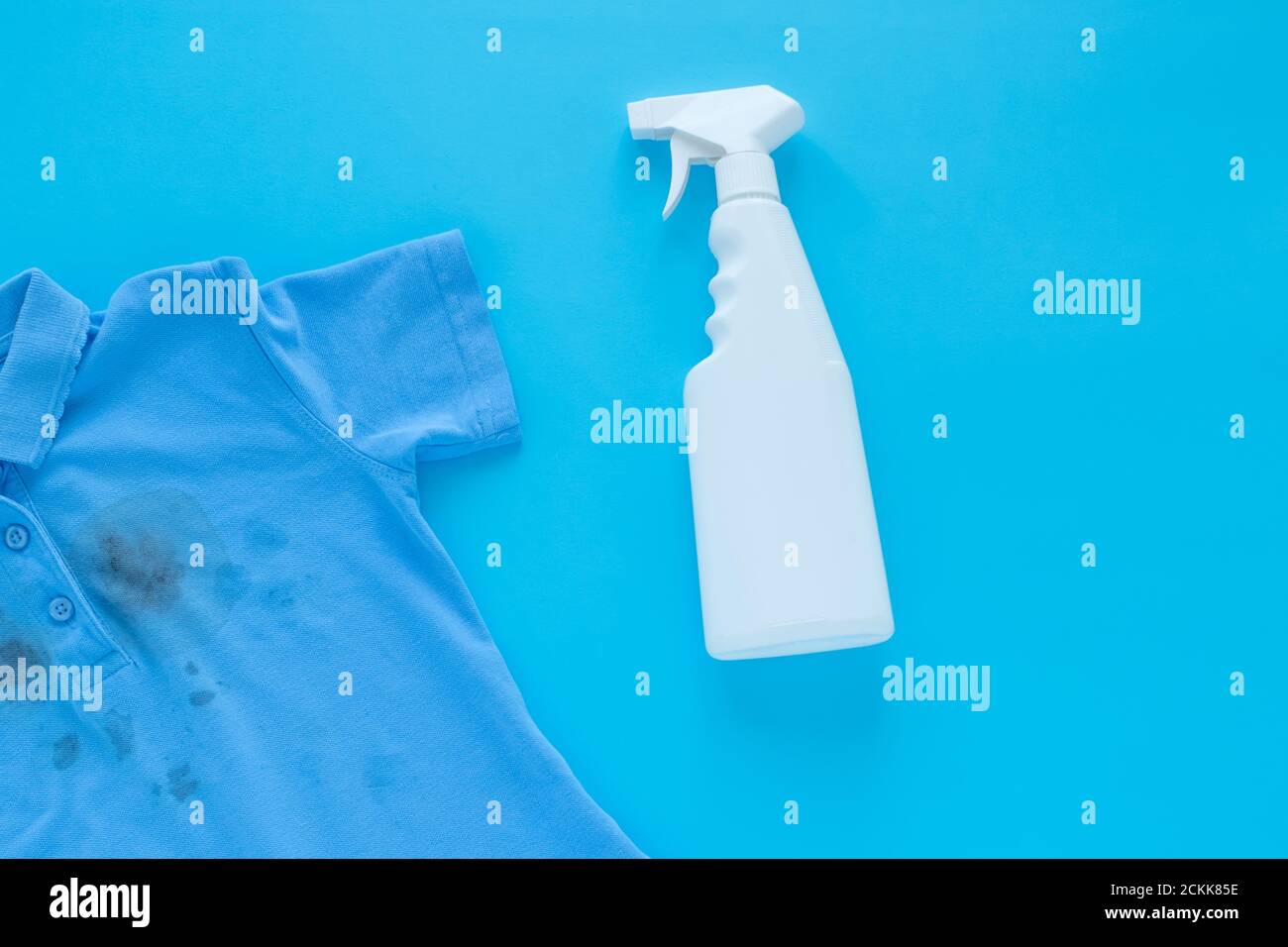 dirty black spots on clothes and stain remover. Stain cleaners. Isolated on a blue background Stock Photo