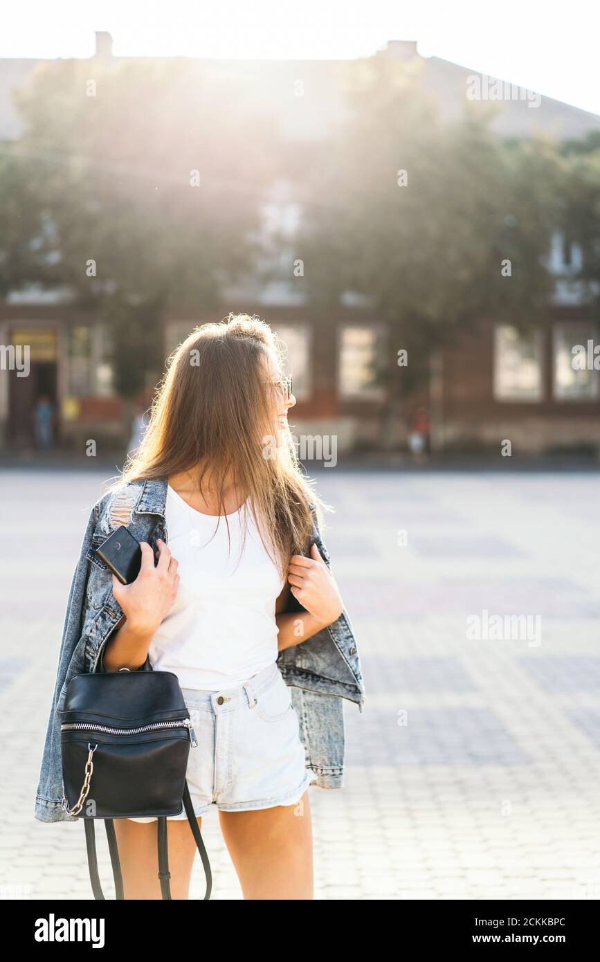 Pretty smiling brunette girl walking on the street Stock Photo - Alamy