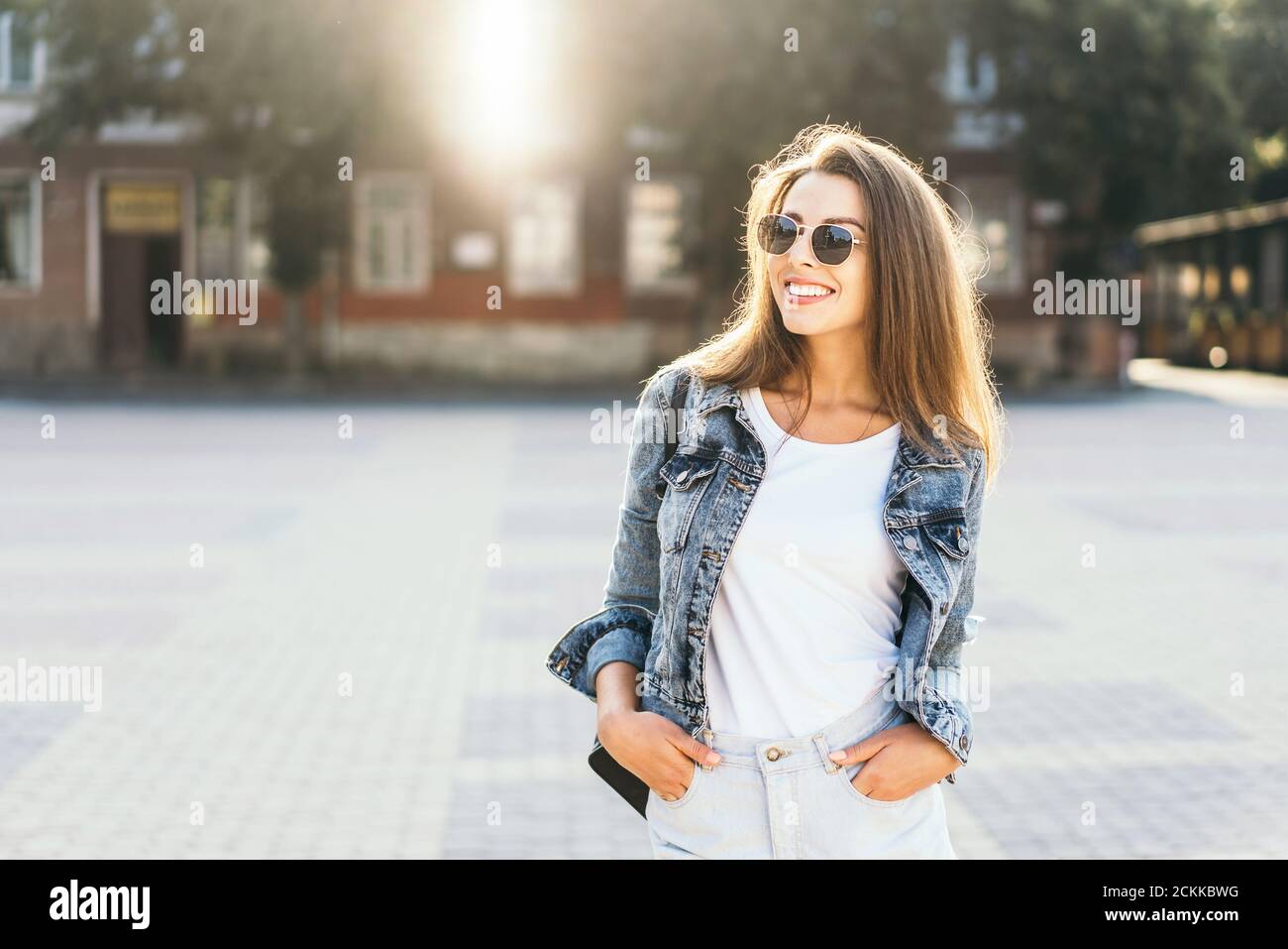 Pretty smiling brunette girl walking on the street Stock Photo - Alamy