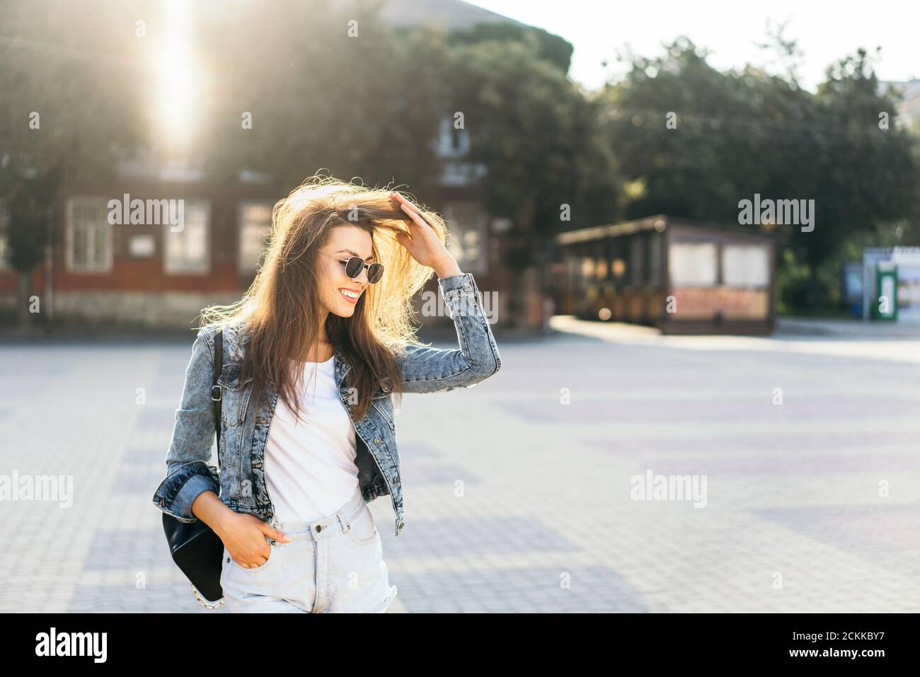 Pretty smiling brunette girl walking on the street Stock Photo - Alamy