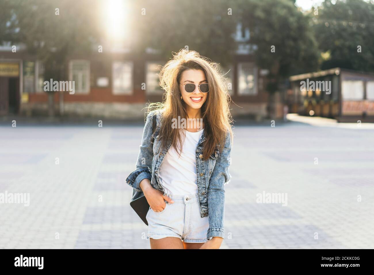 Pretty smiling brunette girl walking on the street Stock Photo - Alamy