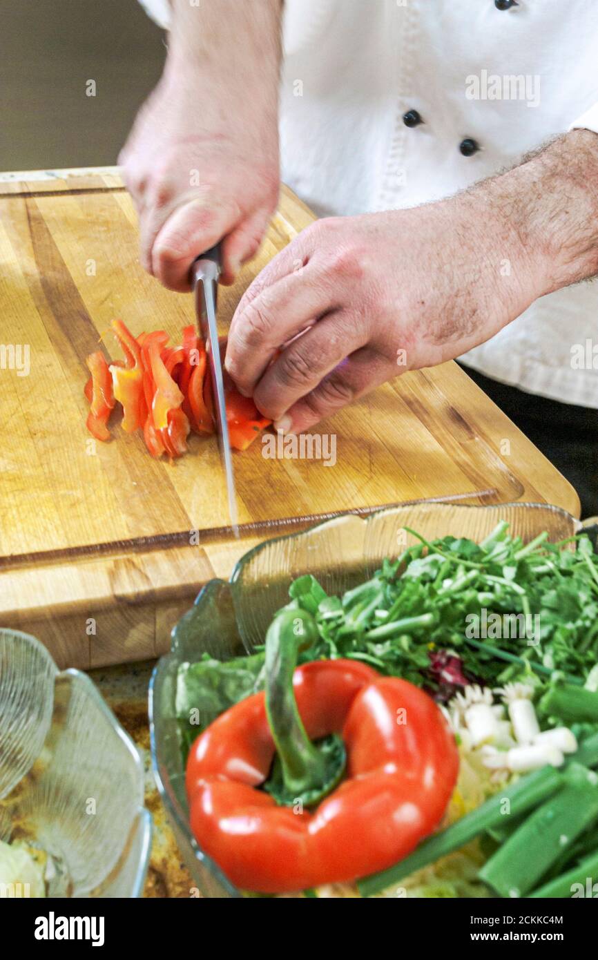 Florida Kendall,Hispanic Latin Latino ethnic immigrant immigrants minority,adult man male,chef makes how to cook video,kitchen cooking cutting carrots Stock Photo