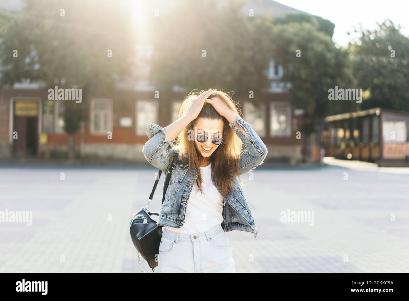Pretty smiling brunette girl walking on the street Stock Photo - Alamy