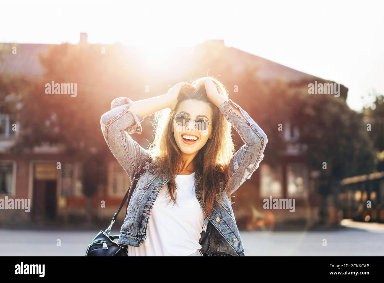 Pretty smiling brunette girl walking on the street Stock Photo - Alamy