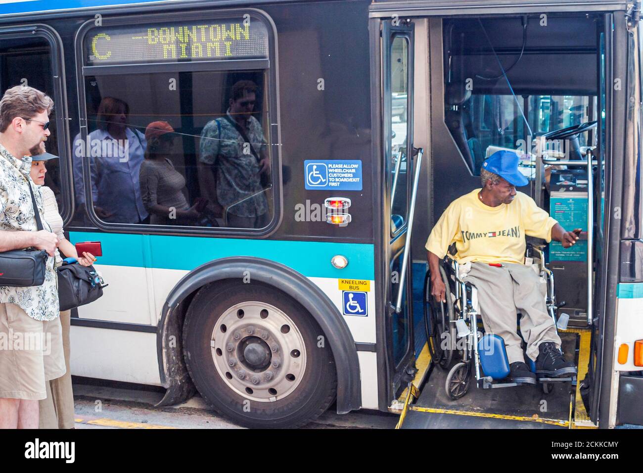 Disabled wheelchair boarding enters public bus passenger passengers