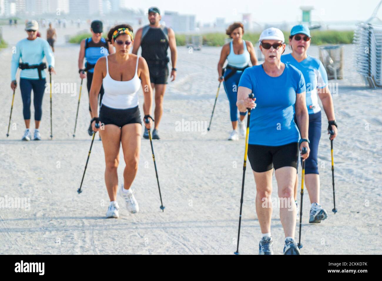 Miami Beach Florida,exercising Nordic walkers walking poles ski fitness,activity on sand public beach beaches,group people using women active mature Stock Photo