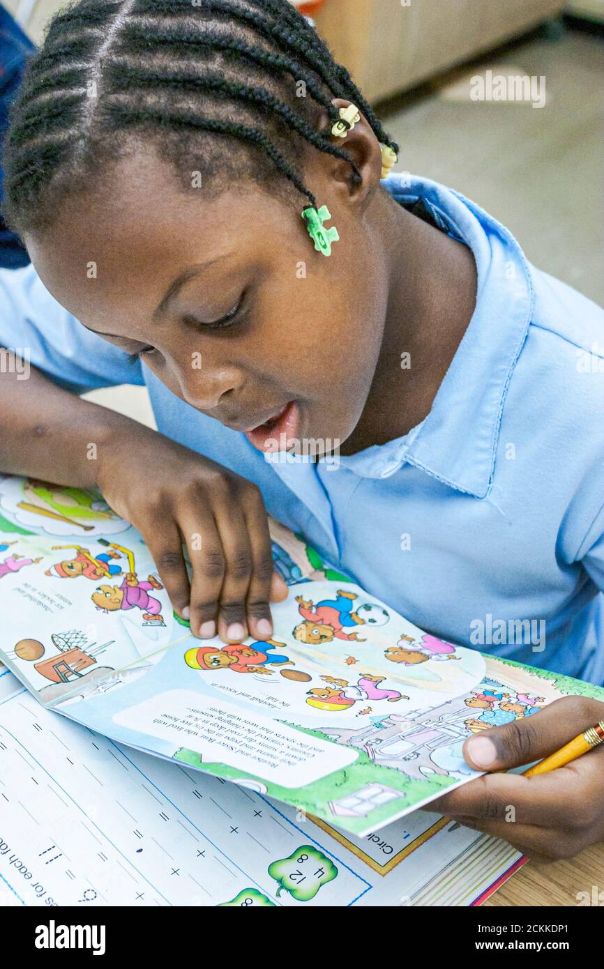 Miami Florida,Frederick Douglass Elementary School,inside interior primary,low income community,Black student girl classroom reading book Stock Photo