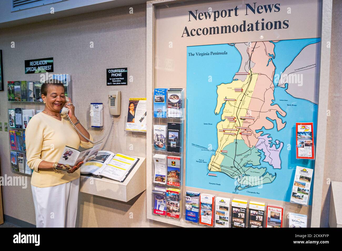 Virginia Newport News Visitors Center centre,inside interior Black African woman female using uses courtesy phone,accommodations brochures folders lea Stock Photo