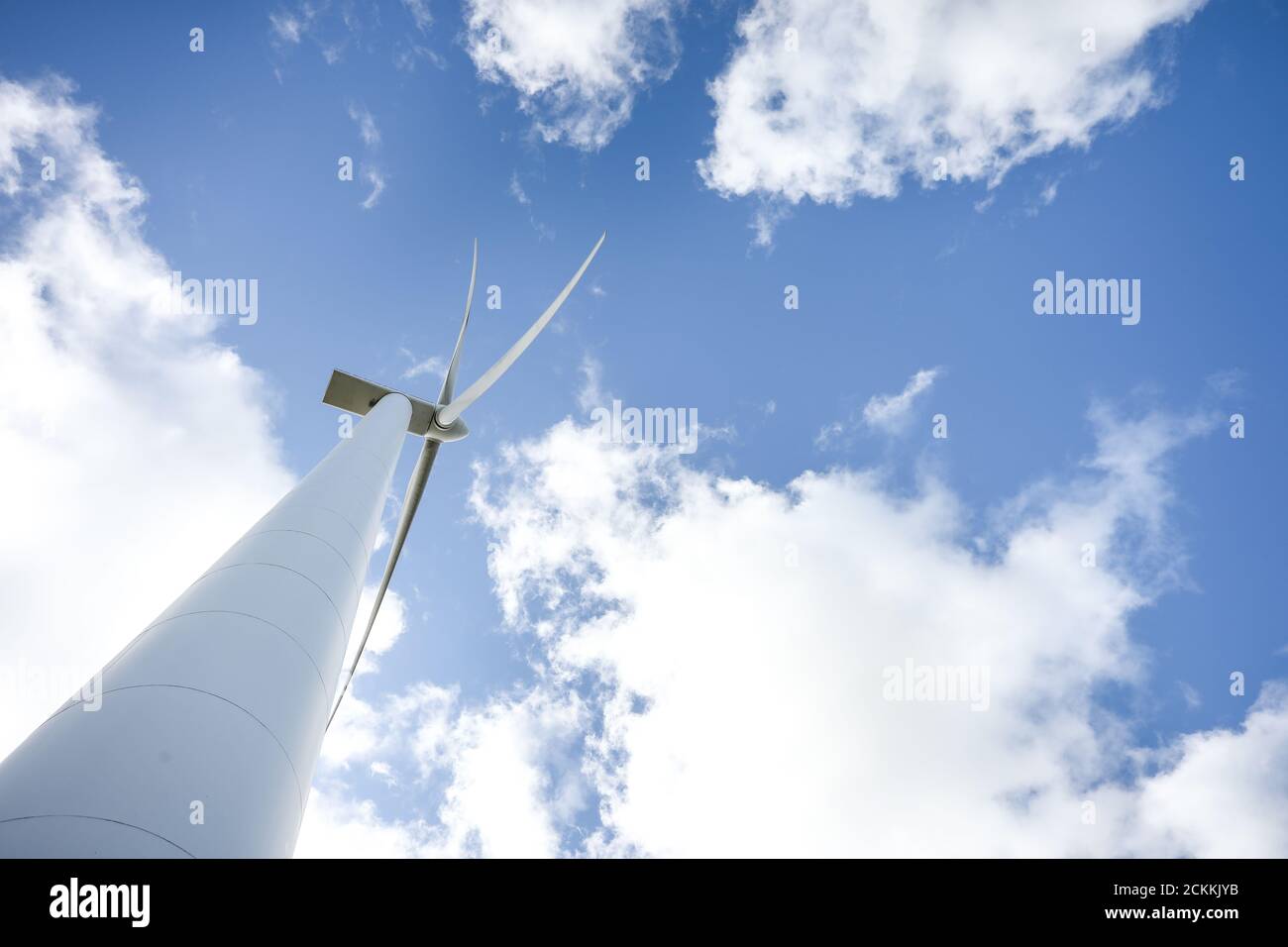 Wind turbine in a sunny day with blue sky and clouds. Wind farm eco ...