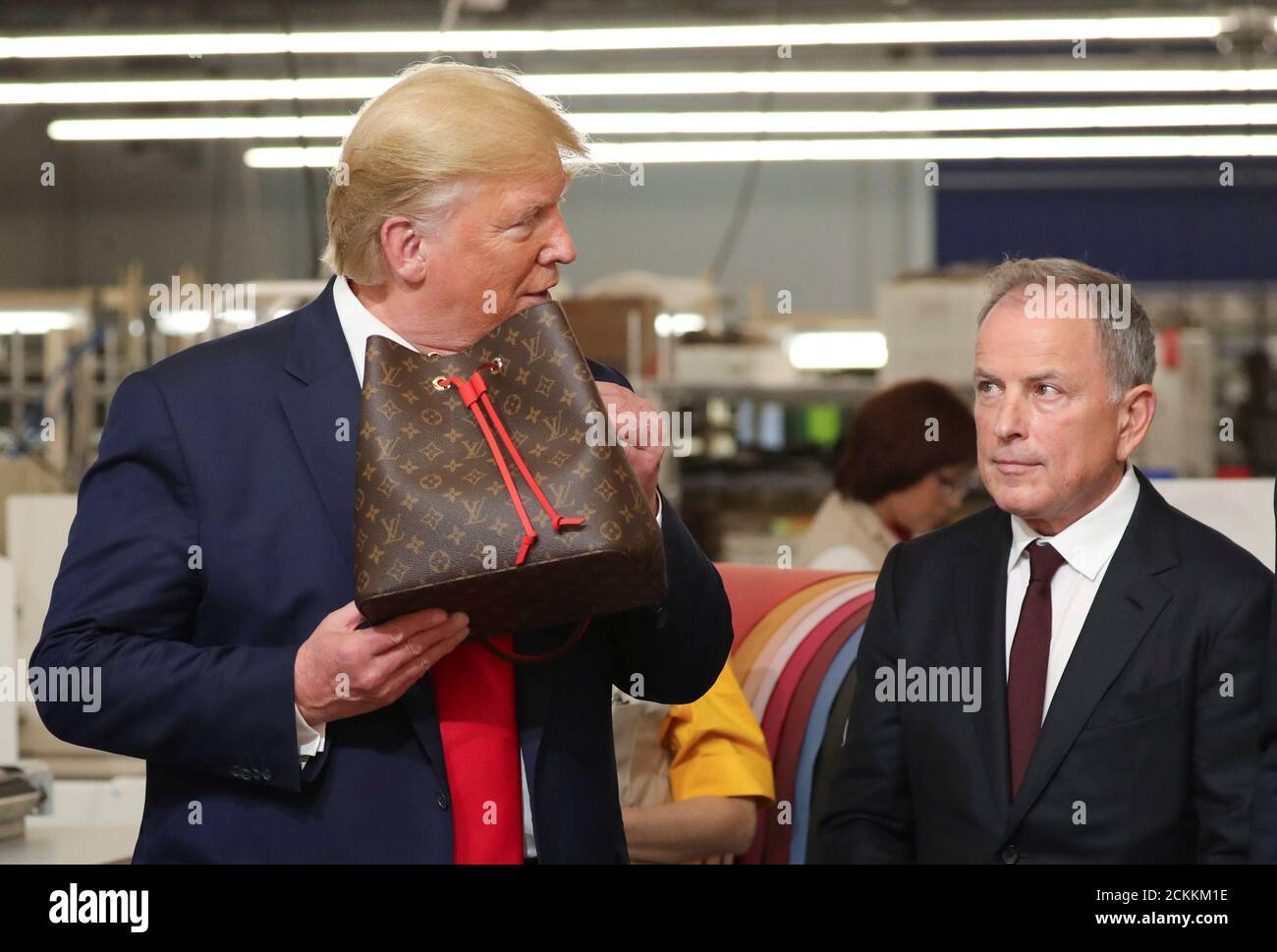 U.S. President Donald Trump holds a purse as Louis Vuitton's CEO Michael  Burke looks on during a visit to the Louis Vuitton Rochambeau Ranch leather  workshop in Keene, Texas, U.S. October 17,