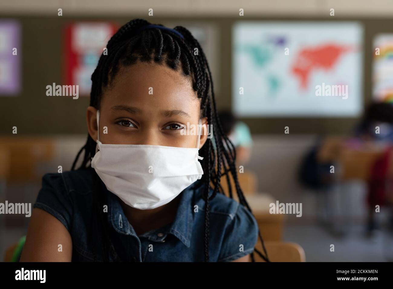 Portrait of a girl wearing face mask sitting in the class at school Stock Photo
