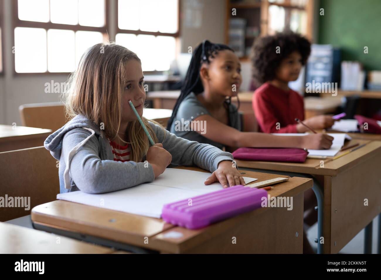 Group of kids sitting on their desk in the class at school Stock Photo