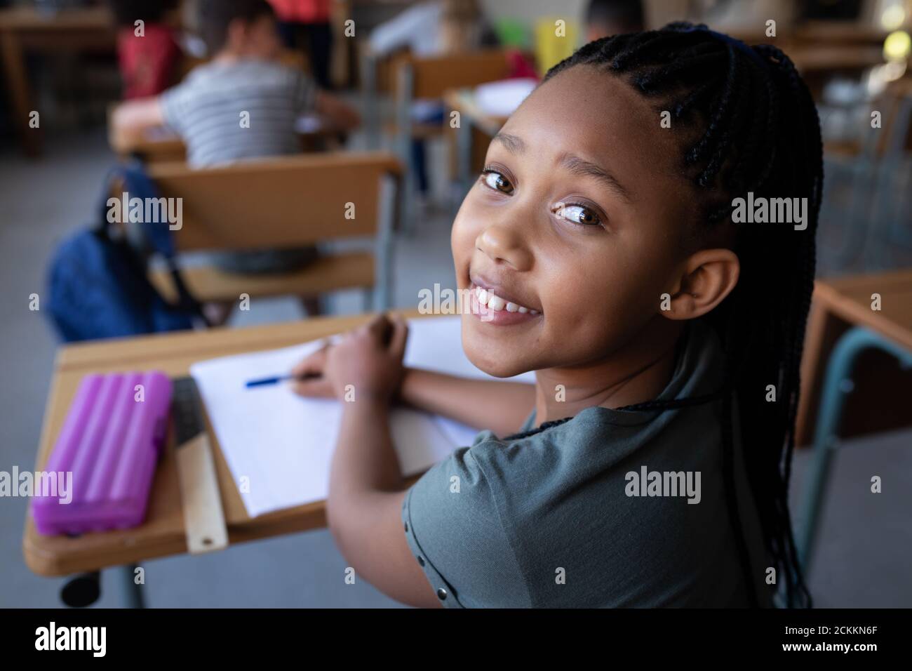 Portrait of girl smiling while sitting on her desk at school Stock ...