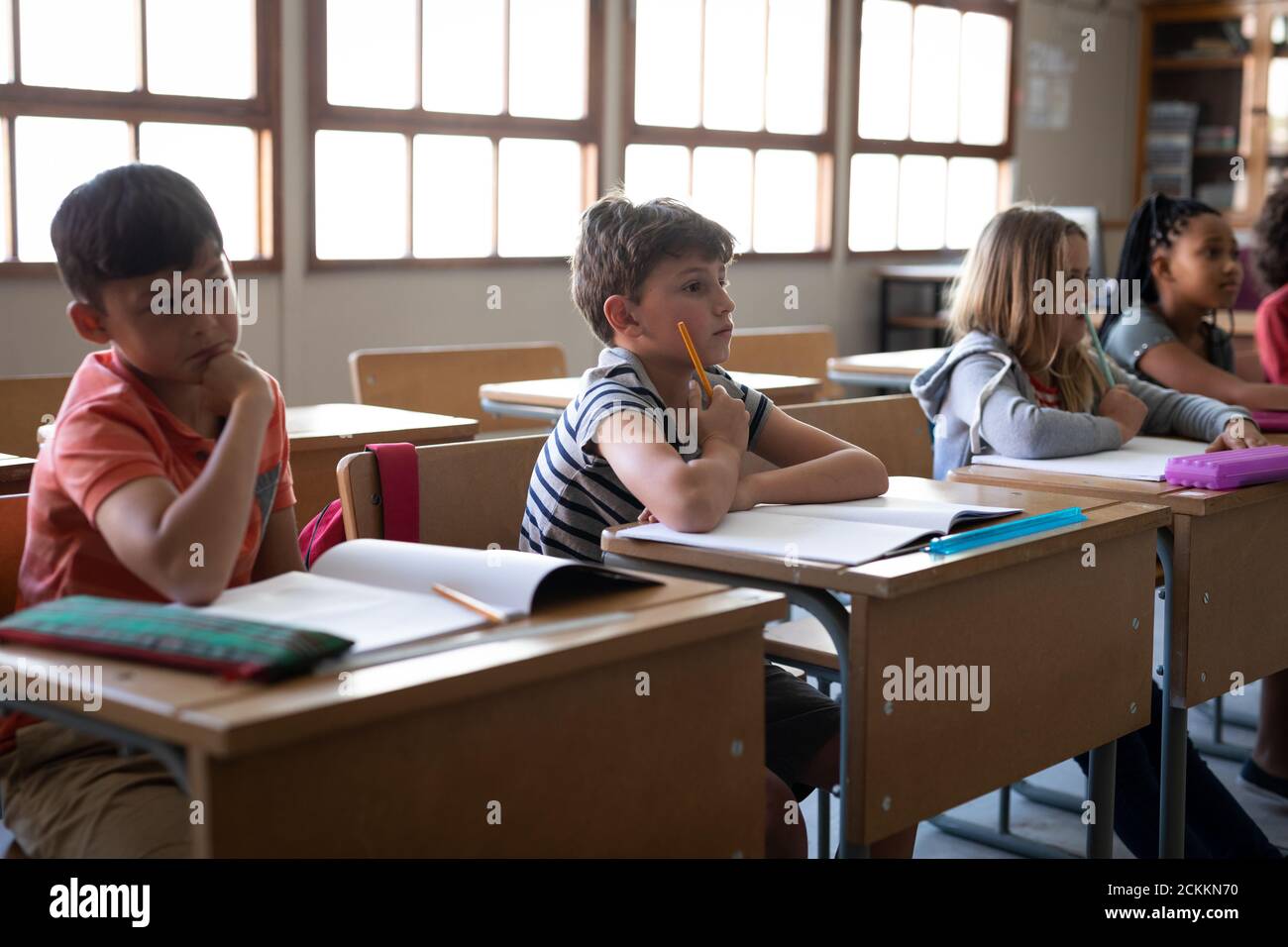 Group of kids sitting on their desk in the class at school Stock Photo
