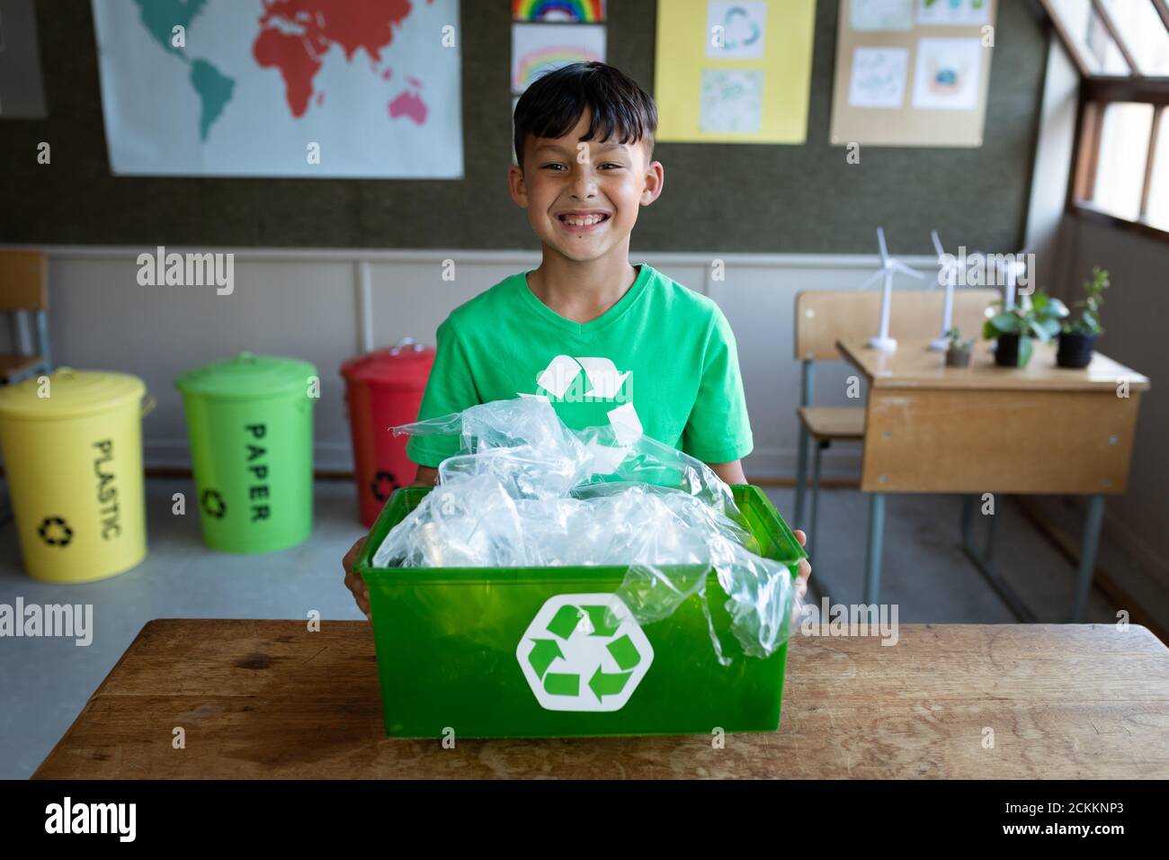 Portrait of boy holding a recycle container in class at school Stock Photo