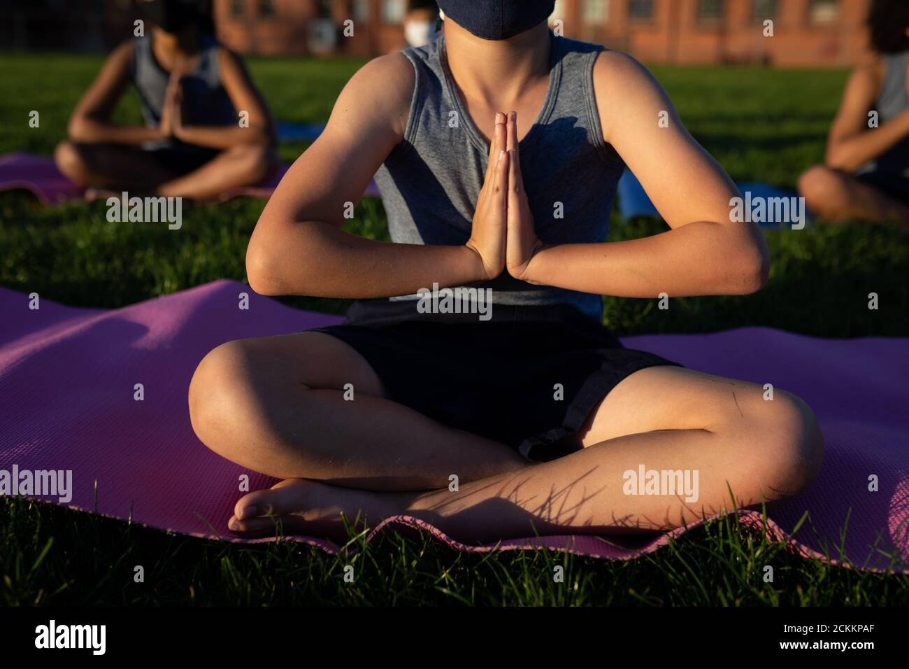 Mid section of boy performing yoga in the garden Stock Photo