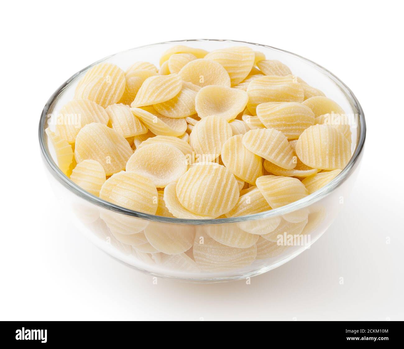 Uncooked orecchiette pasta in glass bowl isolated on white background with clipping path Stock Photo