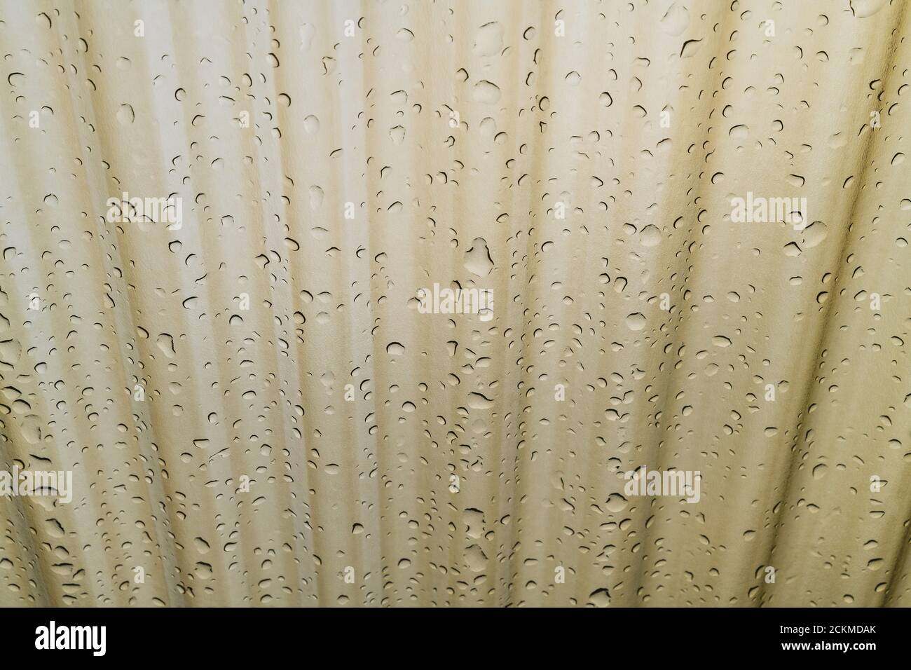 Water drops pattern on corrugated roofing polycarbonate sheet in bronze shade. Wavy plastic glass. High hail resistant shelter. Rain and UV protection. Stock Photo