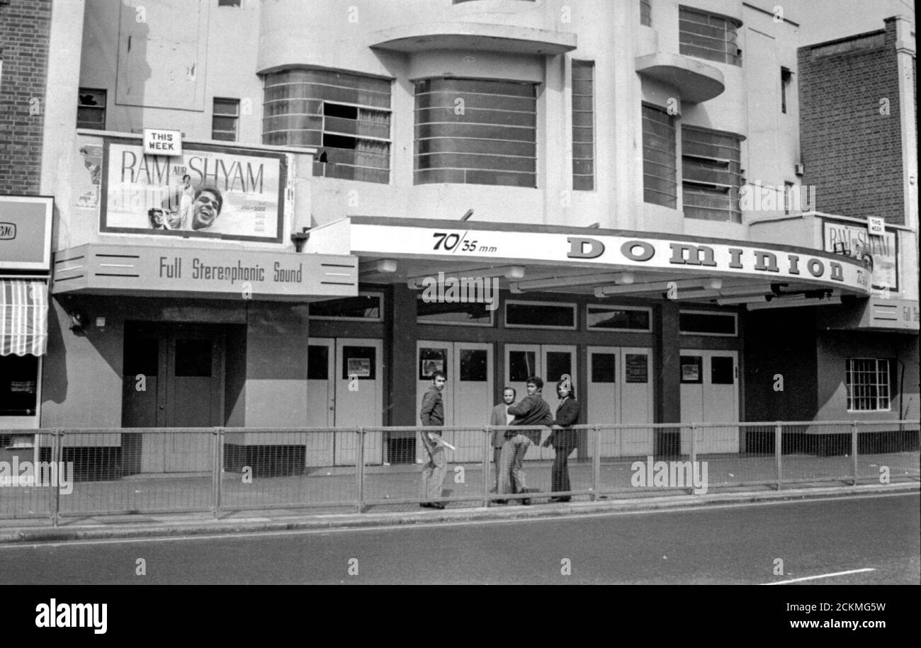 Indian men on the streets of Southall after Idi Amin had expelled Ugandan Asians from Uganda in 1972. Many settled in Southall.  The Dominion Cinema shows the cultural change to the area was very much established. 30,000 people were expelled. Stock Photo