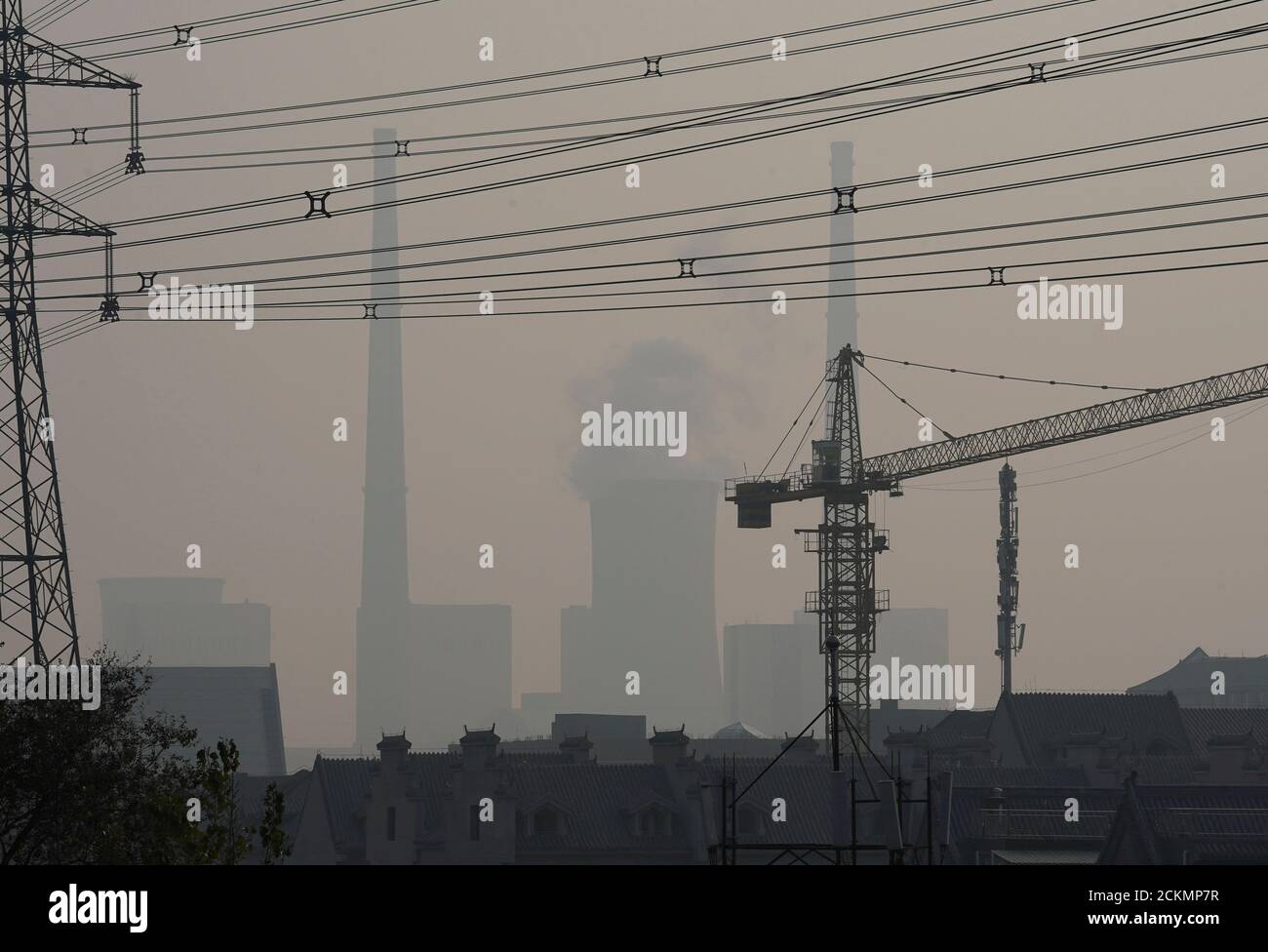 A cooling tower (C) and chimneys are seen at a thermal power plant on a polluted day in Beijing, China, November 3, 2018. REUTERS/Jason Lee Stock Photo