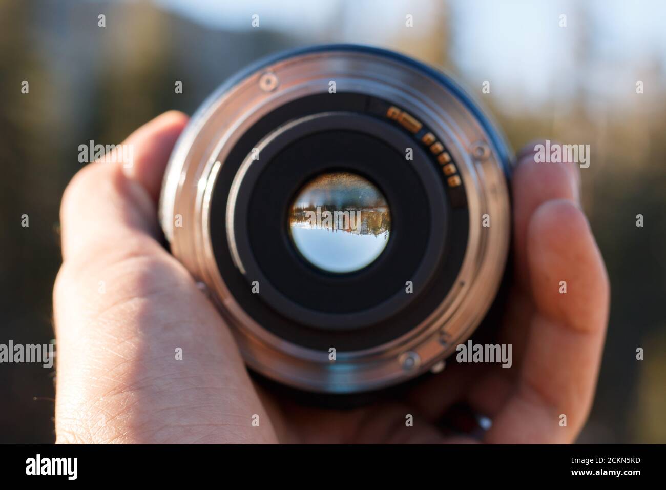 Selective focus shot of a person holding a camera lens Stock Photo - Alamy