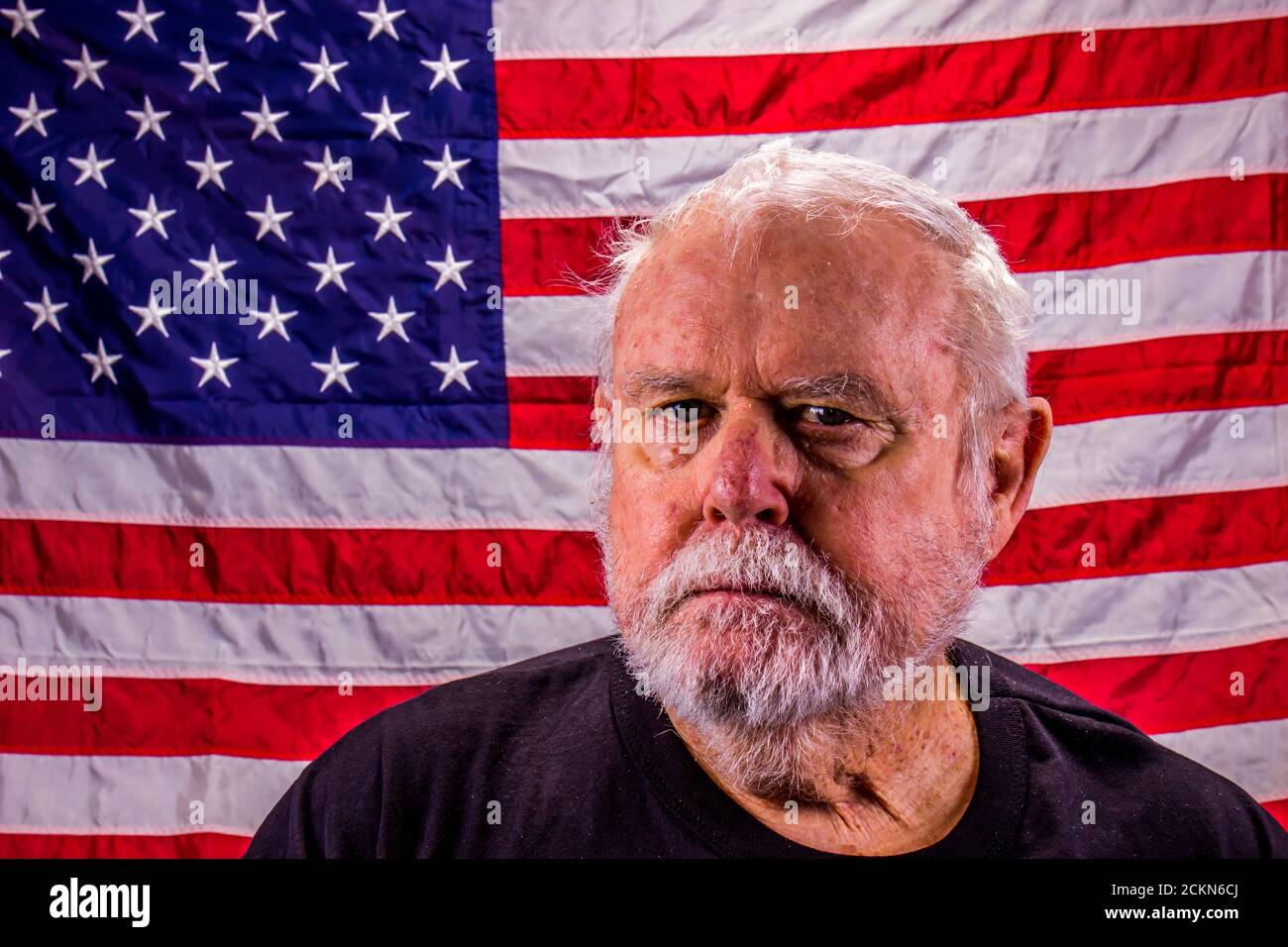 Vietnam Vet Staring Into Camera With American Flag Background Stock Photo