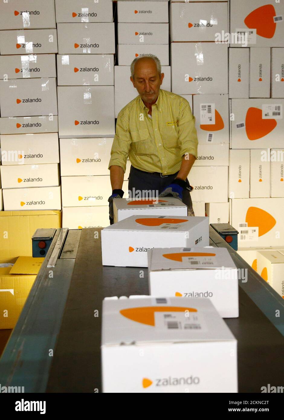 An employee places parcels of online mail order company Zalando, on a  conveyor at the parcel