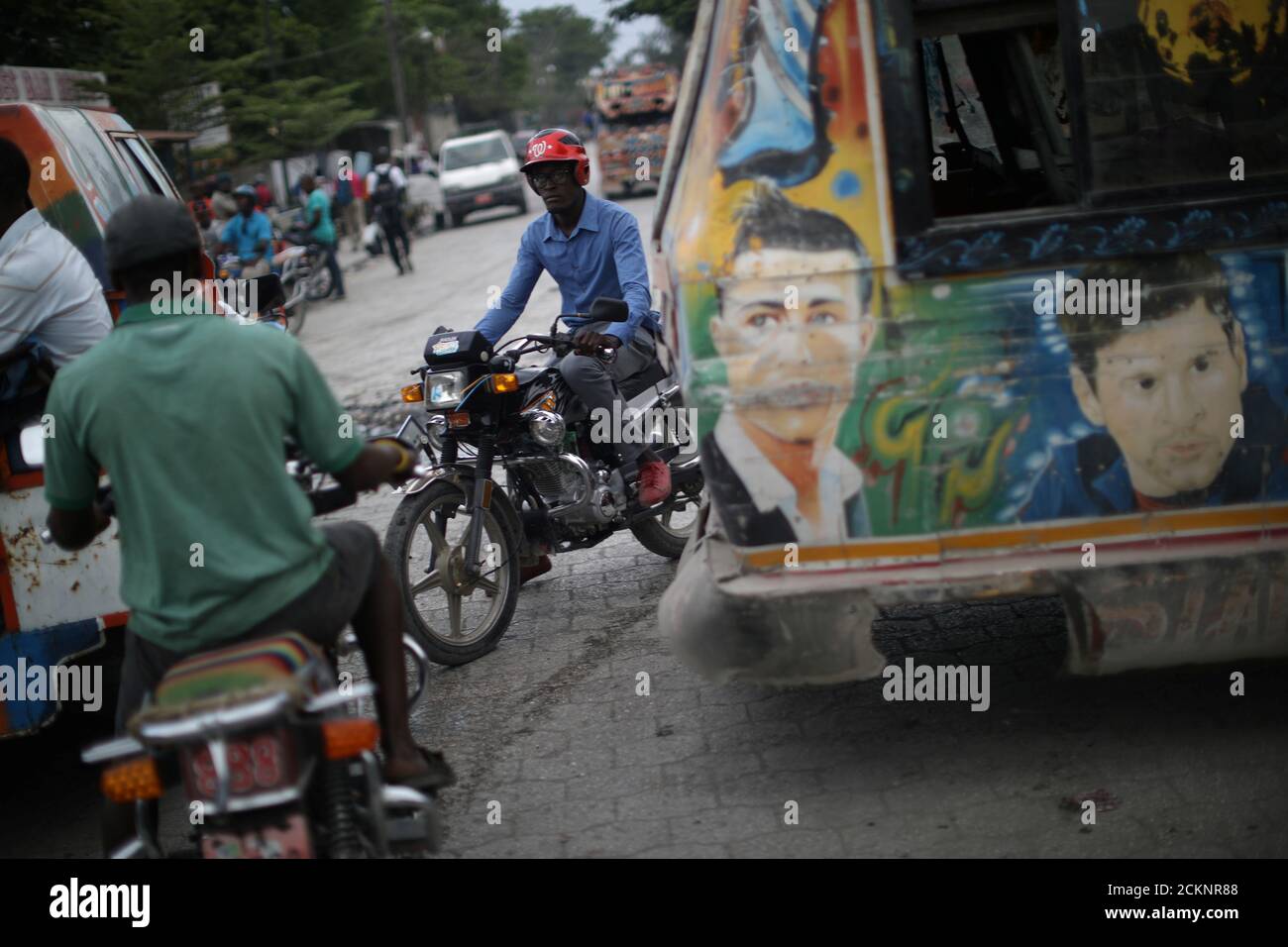 Motorbike drivers pass next to a bus with paintings of soccer players,  Barcelona's Lionel Messi and Real Madrid's Cristiano Ronaldo, in  Croix-des-Bouquets, Haiti, May 3, 2018. Picture taken May 3, 2018.  REUTERS/Andres