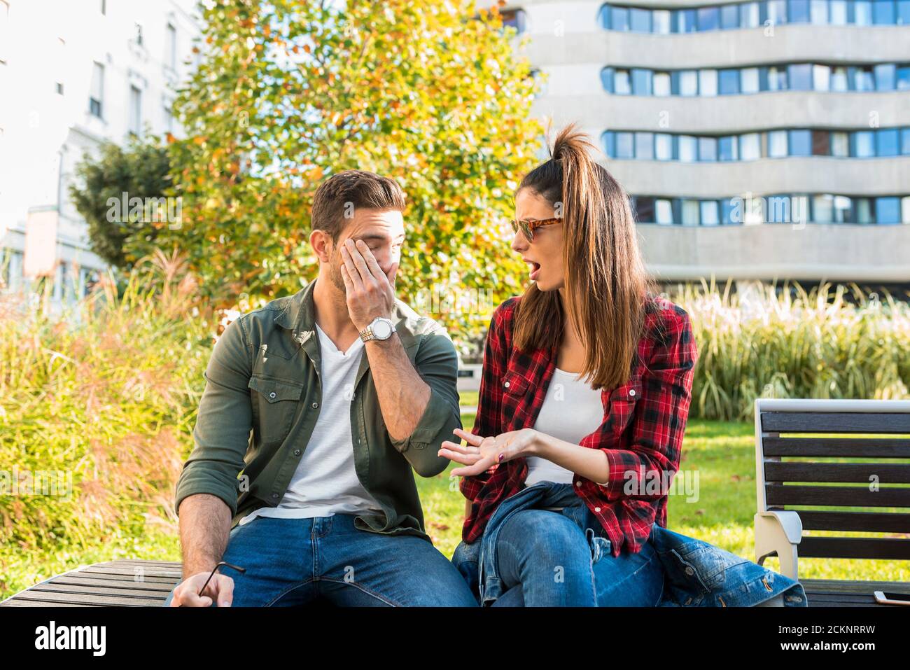 A couple having a argument on a sunny day on a park bench Stock Photo ...