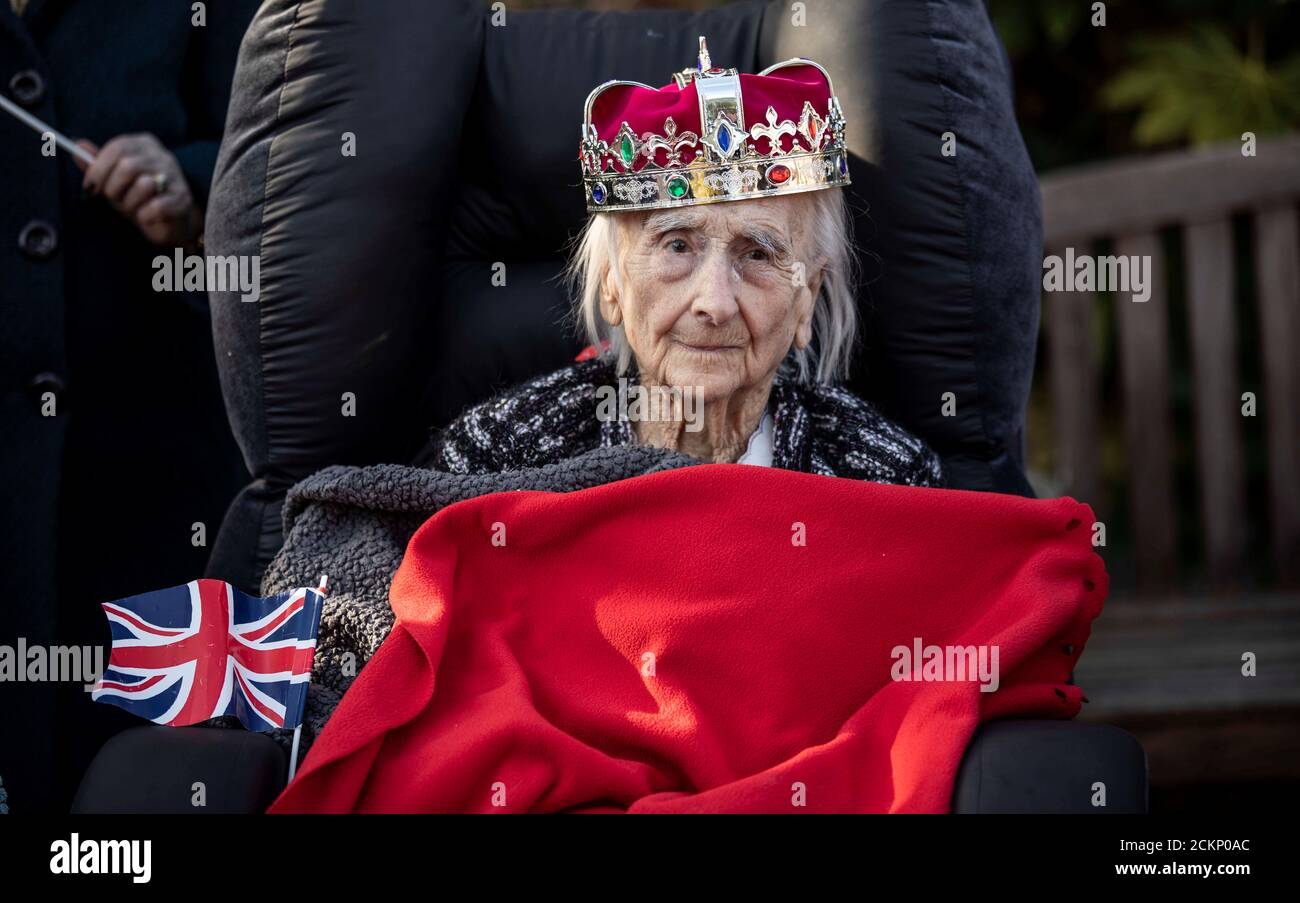 Resident of the Royal British Legion Industries village, Winifred Bennett, aged 101, wears a toy crown and is wrapped up against the cold as she waits for the arrival of Britain's Queen Elizabeth II in Aylesford, Britain, November 6, 2019. Richard Pohle/Pool via REUTERS Stock Photo