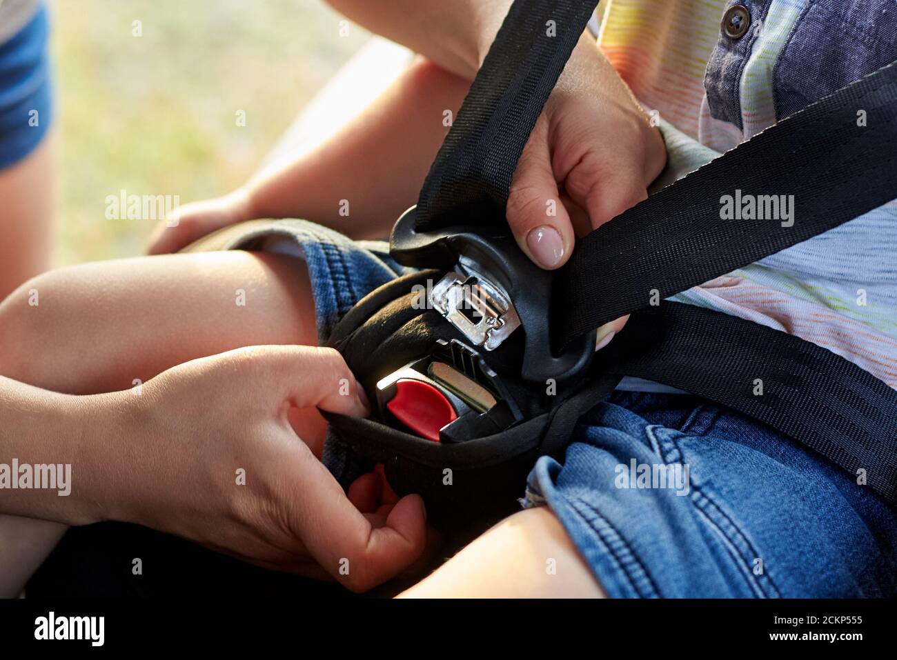 Mom fixes seat belts in a car seat for her baby. Child safety in the