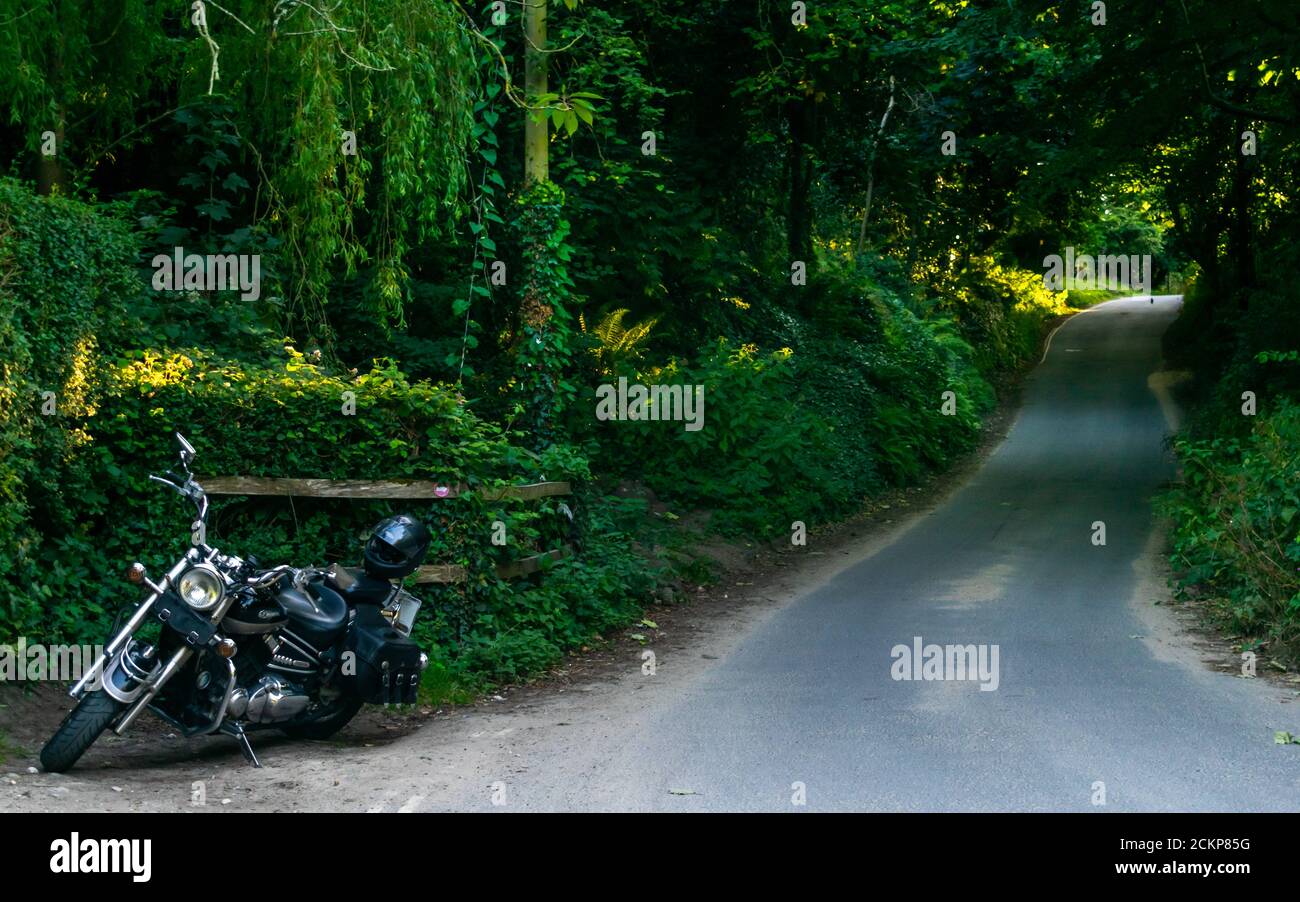 Studland, United Kingdom - 16 July 2020: Oldstyle black Yamaha motorcycle parked by the long forestry road ready to go. Stock Photo