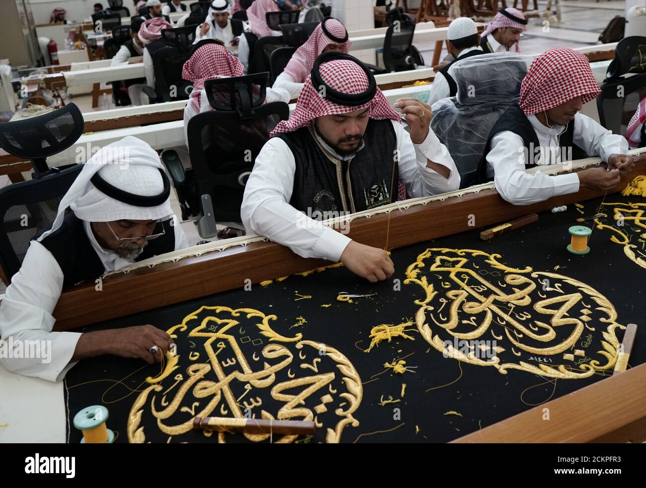 Men embroider the Kiswa, a silk cloth covering the Holy Kaaba, ahead of
