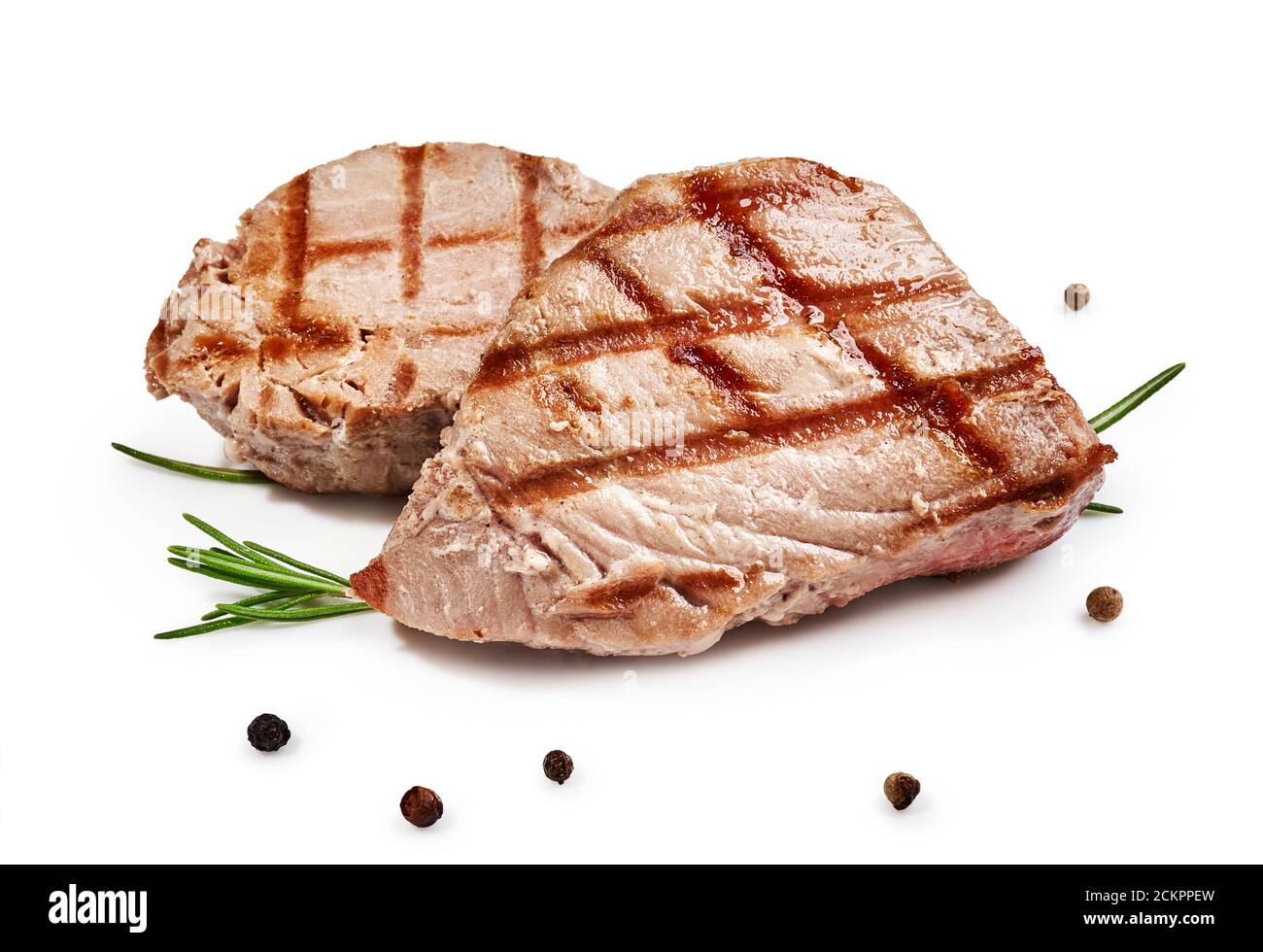 Two grilled tuna steak with rosemary and spices isolated on white Stock Photo