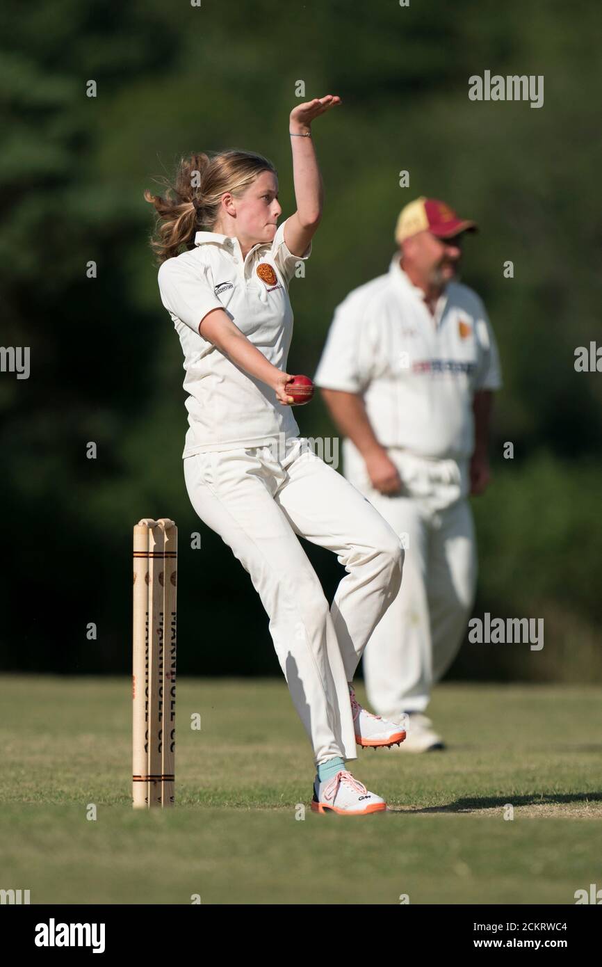 Female cricket player bowling, Dorset, England. Stock Photo