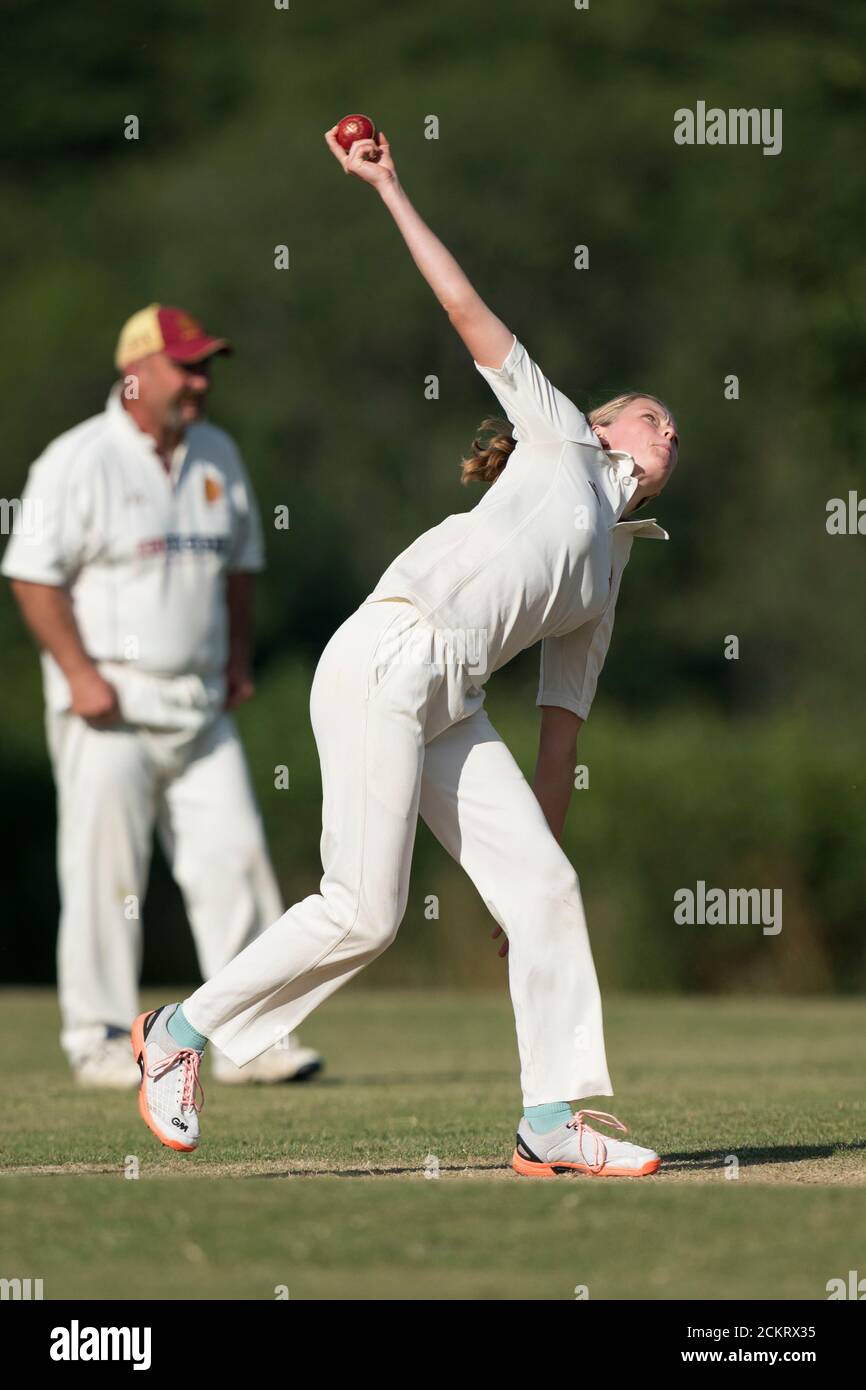 Female cricket player bowling, Dorset, England. Stock Photo