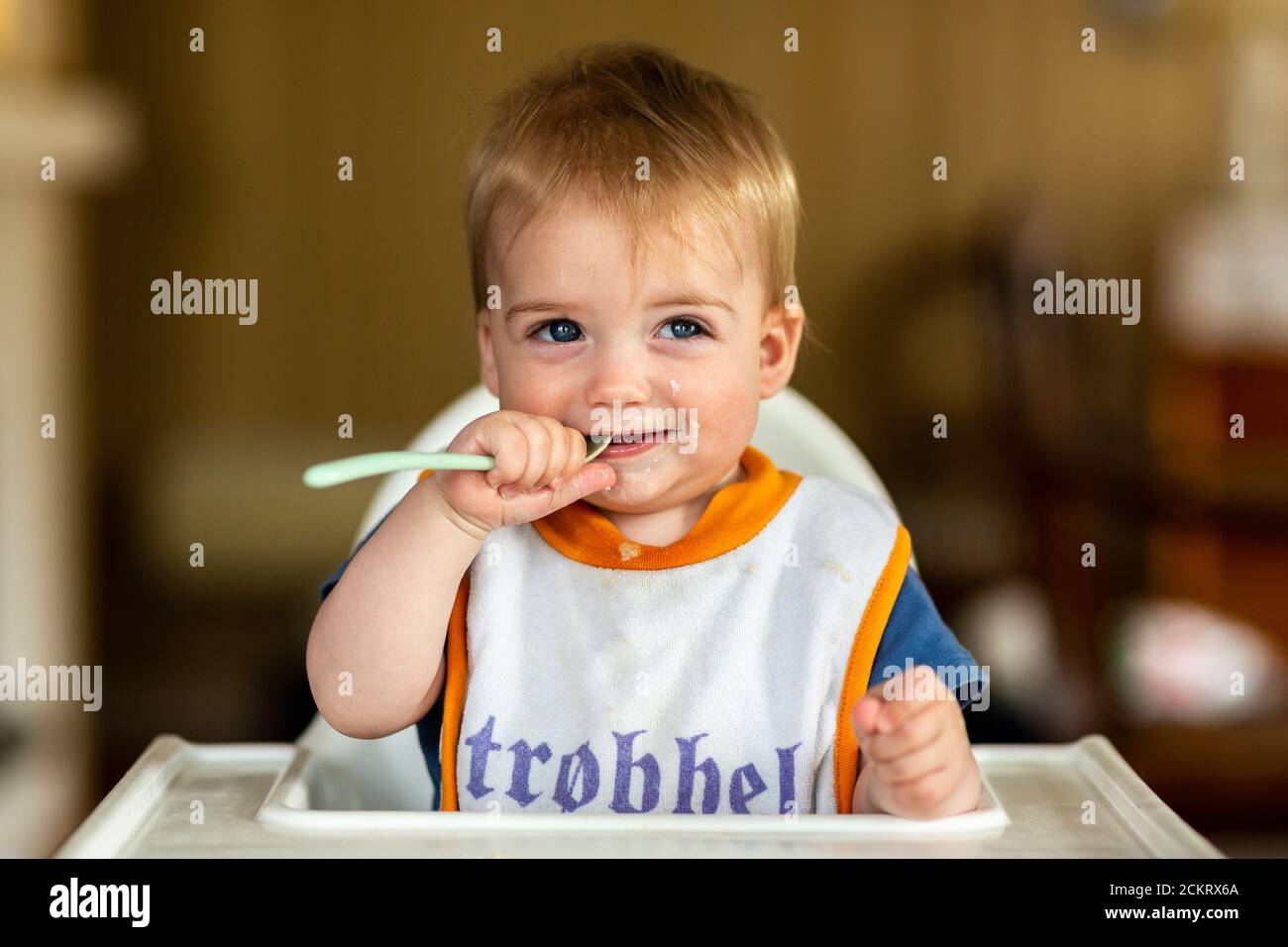 8-12 month old baby boy in a highchair at mealtime Stock Photo