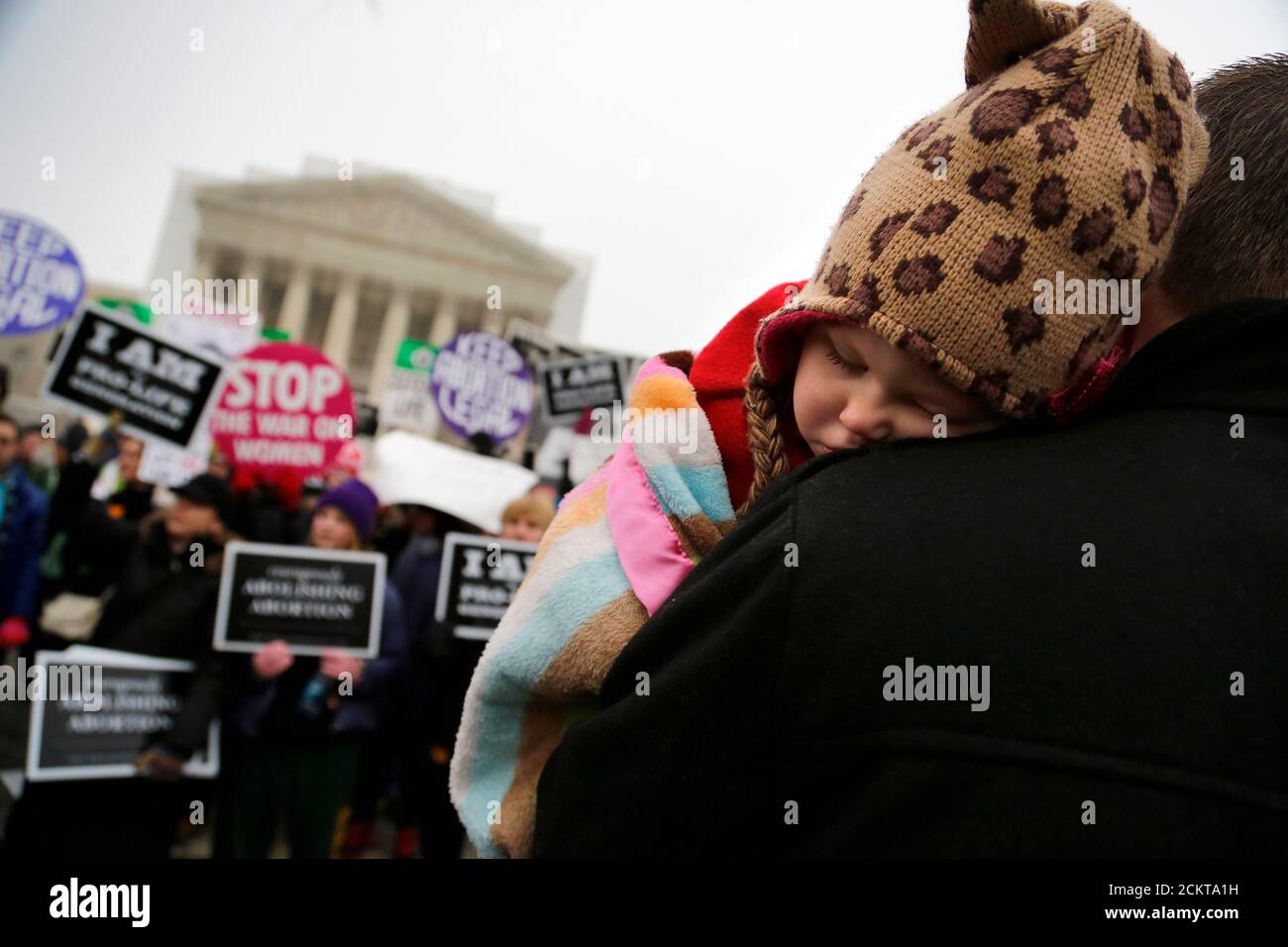 Paisley Fowles, aged one, of Naples, Florida, sleeps on her father's shoulder amidst the din of the annual March for Life rally at the U.S. Supreme Court building in Washington, January 25, 2013. The anti-abortion marchers marked the 40th anniversary of the Roe v. Wade U.S. Supreme Court ruling legalizing abortion, and Pope Benedict expressed support for the demonstrators. REUTERS/Jonathan Ernst Stock Photo